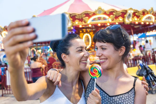 Šťastné mladé ženy s selfie v luna parku — Stock fotografie