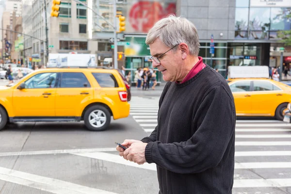 Hombre mayor escribiendo en el teléfono móvil en Nueva York — Foto de Stock