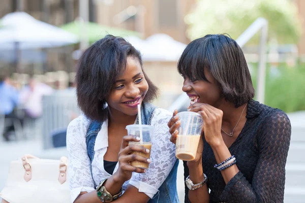 Две красивые черные женщины наслаждаются освежающими напитками в Нью-Йорке — стоковое фото