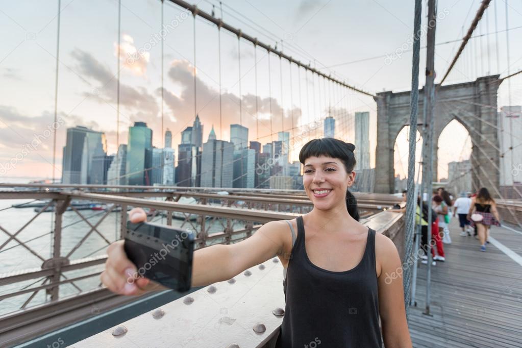 Pretty Young Woman Taking Selfie on Brooklyn Bridge