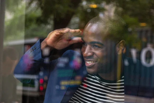 Ung svart man tittar genom fönstret — Stockfoto