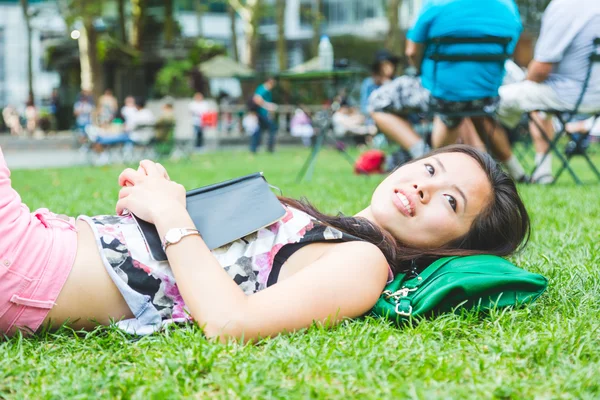 Asiática chica acostándose en la hierba en parque —  Fotos de Stock