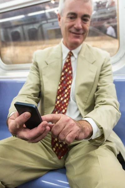 Empresario senior usando teléfono móvil en el tren subterráneo —  Fotos de Stock