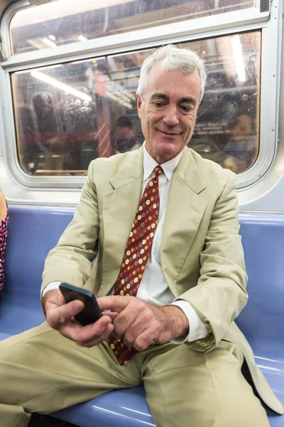 Empresario senior usando teléfono móvil en el tren subterráneo —  Fotos de Stock