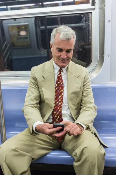 高级商人在地铁列车中使用手机 — 图库照片