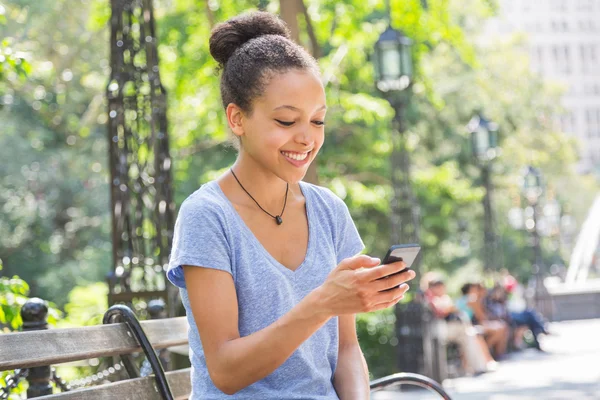 Schöne gemischte Rasse junge Frau tippt auf Handy — Stockfoto