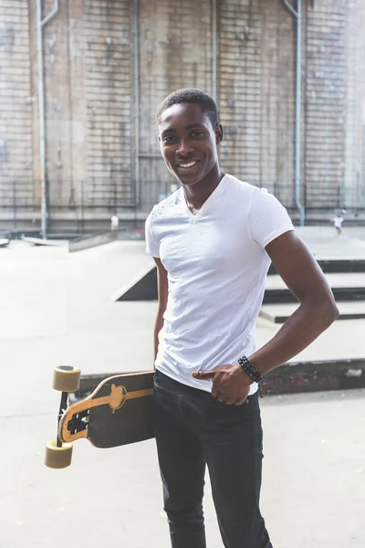 Schwarzer Junge mit Longboard im Park — Stockfoto