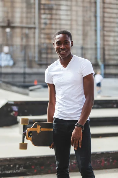 Zwarte jongen met longboard in park — Stockfoto