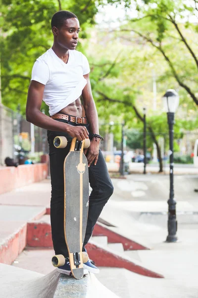 Preto menino com longboard no parque — Fotografia de Stock