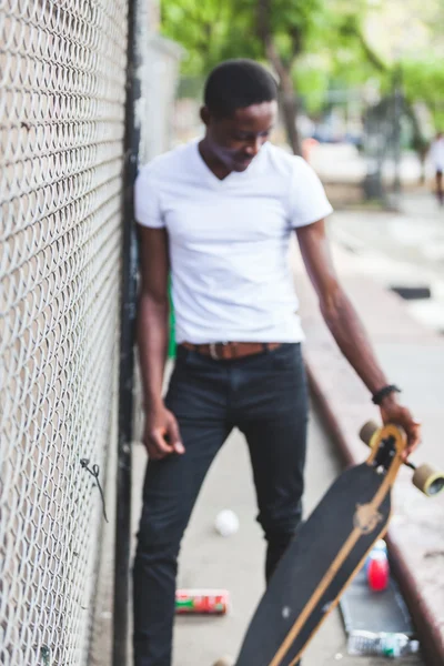 Чернокожий мальчик с лонгбордом в парке — стоковое фото