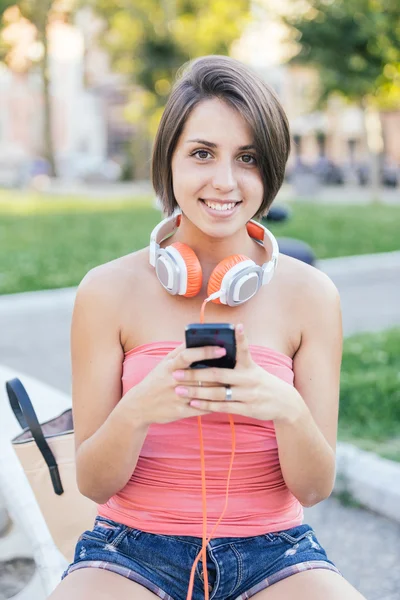 Fille avec téléphone au parc — Photo