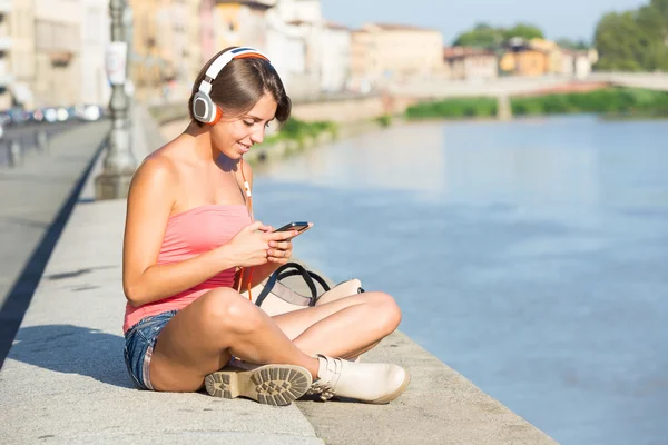 Дівчина з навушниками і телефон в місті — Zdjęcie stockowe