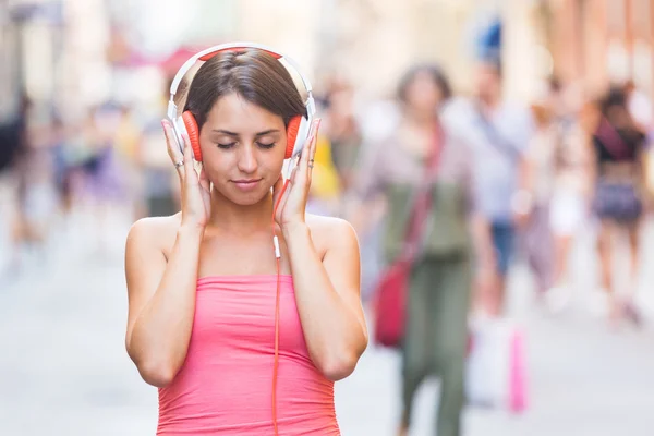 Femme écouter de la musique en ville — Photo