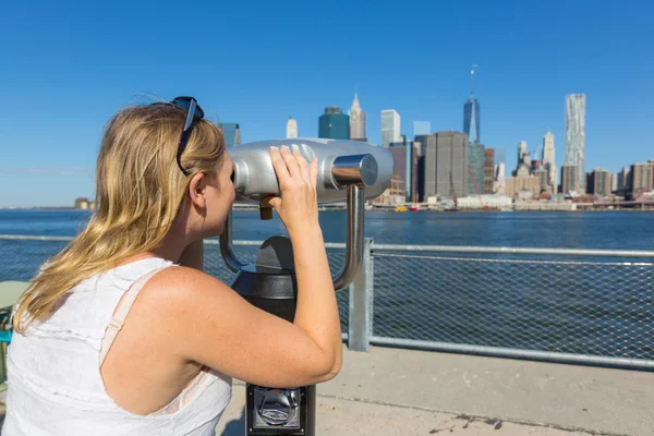 Frau blickt durch Fernglas — Stockfoto