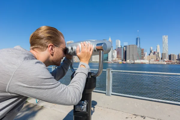 Muž se dívá dalekohledem — Stock fotografie