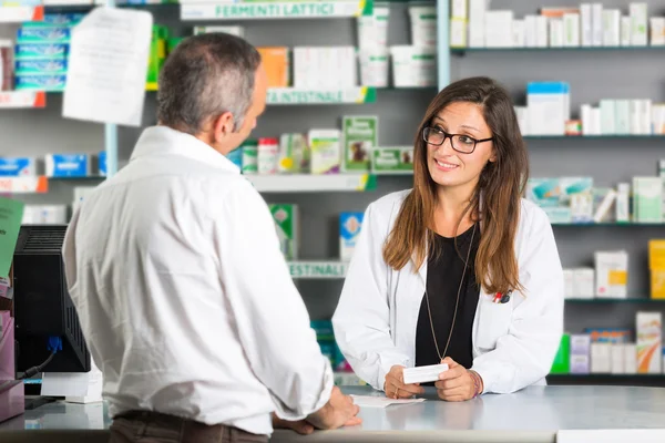 Farmacêutico e cliente em uma farmácia — Fotografia de Stock