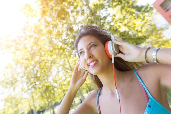 Молодая женщина слушает музыку в парке — стоковое фото