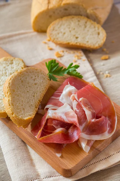 Tranches de pain et jambon sur une planche à découper — Photo