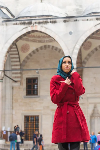 Young Arabian kvinna som bär slöja framför en moské — Stockfoto