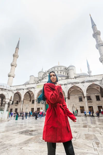 Young Arabian kvinna som bär slöja framför en moské — Stockfoto
