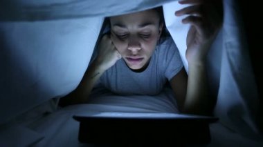Yorgun kadın çarşaf altında dijital Tablet kullanma