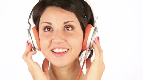 Mujer joven sonriente escuchando música con auriculares — Vídeos de Stock