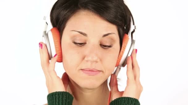 Грустная молодая женщина слушает музыку в наушниках — стоковое видео