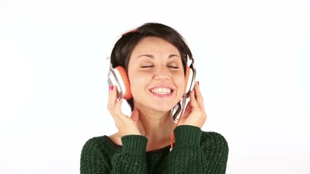 Mujer joven sonriente escuchando música con auriculares — Vídeo de stock