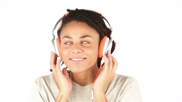 Mujer joven sonriente escuchando música con auriculares — Vídeos de Stock