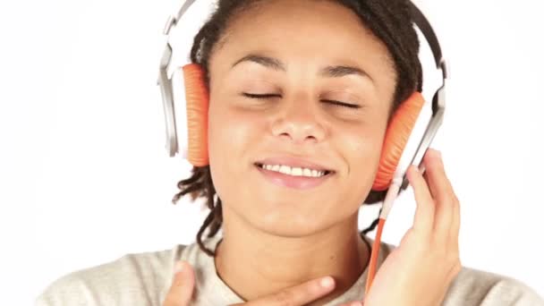 Mujer joven sonriente escuchando música con auriculares — Vídeos de Stock