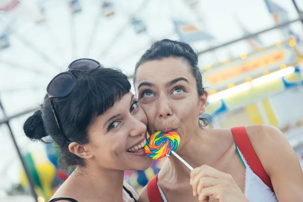 Feliz joven mujeres comiendo piruleta —  Fotos de Stock