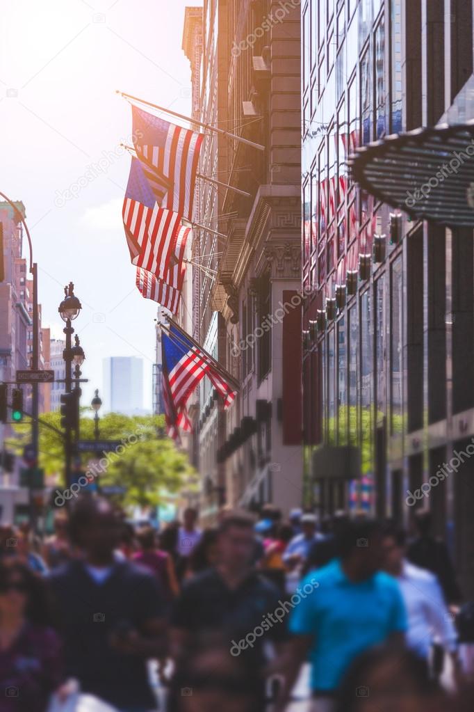 Crowded Sidewalk in New York and United States Flags