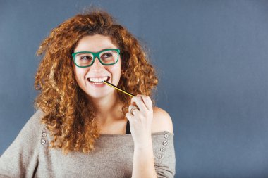 Gri arka plan üzerinde dalgın kıvırcık genç kadın