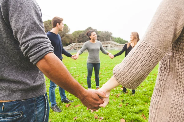 Groupe multiethnique d'amis tenant la main dans un cercle — Photo