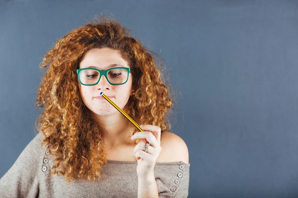 Ragazza riccia pensierosa su sfondo grigio — Foto Stock