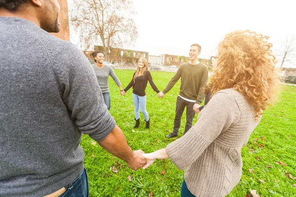 Multiethnische Gruppe von Freunden Händchen haltend im Kreis — Stockfoto