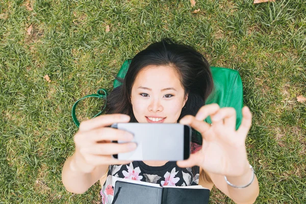 Fille sur herbe prise selfie — Photo