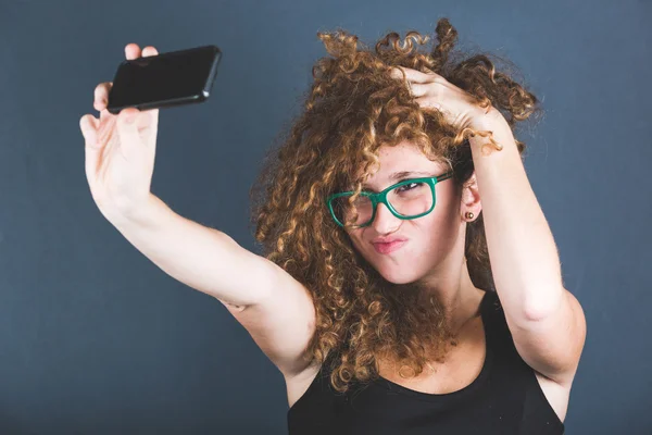 Mosolygó göndör nő vesz Selfie — Stock Fotó