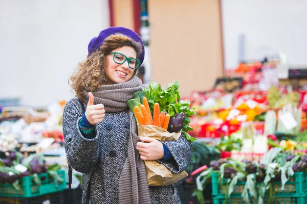 Jonge vrouw kopen groenten bij lokale markt — Stockfoto