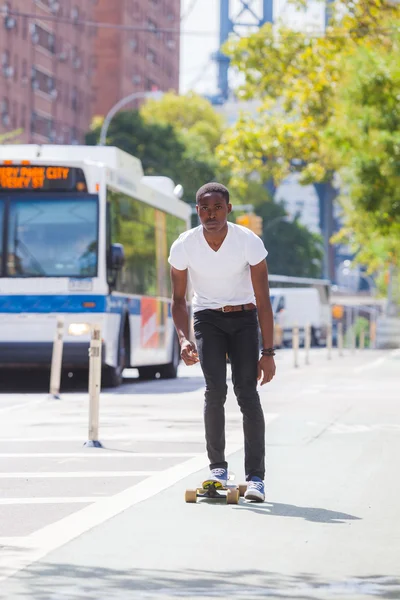 Schwarzer Junge skatet mit Longboard auf der Straße — Stockfoto