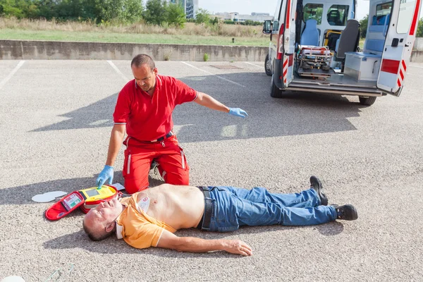 Läkare som ger första hjälpen med en Defibrillator — Stockfoto