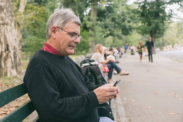 Senior te typen op mobiel — Stockfoto