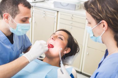 Diş hekimi ve diş hasta diş inceleyerek Yardımcısı.