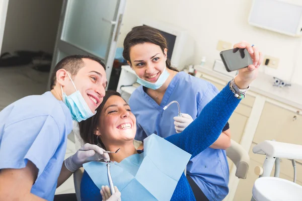 Счастлив, стоматолог и ассистент, делающие селфи все вместе . — стоковое фото