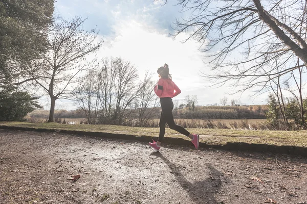 Jovem mulher Jogging no caminho fora da estrada na parte da manhã . — Fotografia de Stock