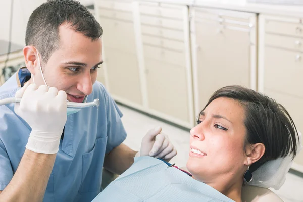 Dentista asustando a paciente con el taladro . — Foto de Stock