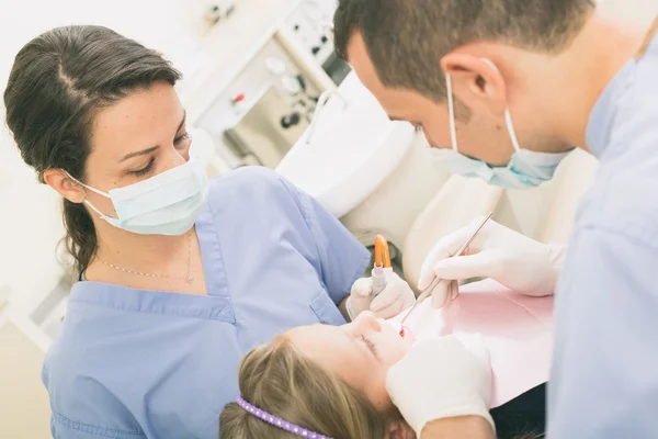 Dentiste et assistante dentaire examinant les dents des jeunes filles . — Photo