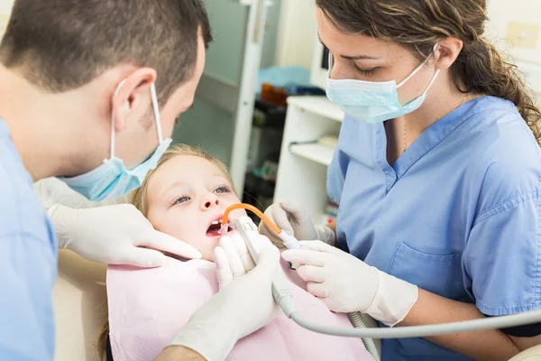 Tandläkare och Dental Assistant undersöka ung flicka tänder. — Stockfoto