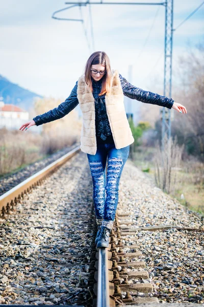 Piękna młoda kobieta chodząca w równowadze po torach kolejowych. - Co? — Zdjęcie stockowe