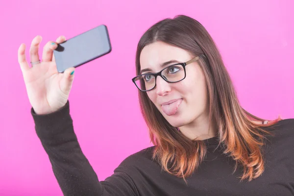 Jovem mulher tomando um selfie no fuchsia fundo . — Fotografia de Stock